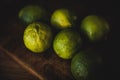 Green lime fruits lying on a wooden kitchen surface