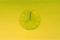 Green lime round modern analog glass clocks hang on a light yellow green wall. Shows the current time eight pm