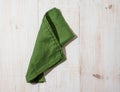 Green linen kitchen towel or textile napkin on white wooden background. Royalty Free Stock Photo