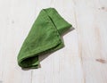 Green linen kitchen towel or textile napkin on white wooden background. Royalty Free Stock Photo