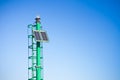 Green little lighthouse with staircase and solar cells against a blue sky - image with copy space Royalty Free Stock Photo