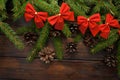 Green living spruce branches on a dark wooden background. New Year background with cones and red bows. Top view Royalty Free Stock Photo