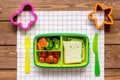 Green lunch box for kid on wooden background top view