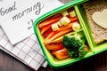 Green lunch box for kid on wooden background top view