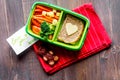 Green lunch box for kid on wooden background top view