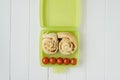 Green lunchbox with scrolls and tomato Royalty Free Stock Photo