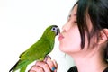 Green macaw bird pet kiss to woman.