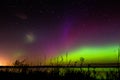Green, magenta and purple aurora borealis with meteor