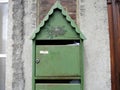 Green mailbox in the with the image of a bird on a nest on it