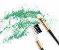 Green make up eye shadow crushed and brushes on white Royalty Free Stock Photo