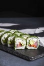 Green Maki Sushi - roll made of smoked salmon, cream cheese and cucumber inside. Dill outside. Royalty Free Stock Photo