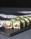 Green Maki Sushi - roll made of smoked salmon, cream cheese and cucumber inside. Dill outside. Royalty Free Stock Photo