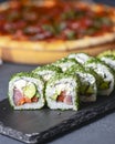 Green Maki Sushi - roll made of smoked salmon, cream cheese and cucumber inside. Dill outside. Royalty Free Stock Photo