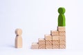 A green man stands at the top of a social or career ladder. Concept of business success. Stairs of people. Use other workers. A wo Royalty Free Stock Photo