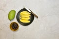 Green mango and ready to eat on black dish with sweet fish sauce on grungy cement floor, Thai popular food Royalty Free Stock Photo