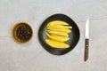 Green mango and ready to eat on black dish with sweet fish sauce on grungy cement floor, Thai popular food Royalty Free Stock Photo