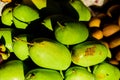 Green mangoes stacked for sale