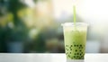 Green matcha bubble tea in cup against nature background. Antioxidant and dietary vegan cocktail for healthy breakfast