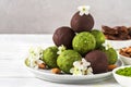 Green matcha energy balls or energy bites with energy balls in chocolate glaze with spring flowers. Healthy vegan snacks Royalty Free Stock Photo