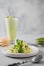 Green matcha ice cream and tea in latte glass on grey table Royalty Free Stock Photo