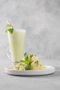 Green matcha ice cream and tea in latte glass on grey table. Royalty Free Stock Photo