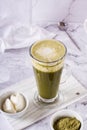 Green matcha ice tea with cream cheese in a glass on the table. Trendy homemade drink. Vertical view Royalty Free Stock Photo