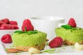Green matcha vegan raw cakes with raspberries, mint, nuts and coffee cup for breakfast. healthy delicious food Royalty Free Stock Photo