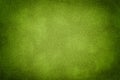 Green matte background of suede fabric with vignette. Texture of velvet textile