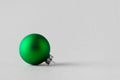 Green matte Christmas ball on a seamless grey background