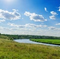 Green meadow with river and clouds in blue sky Royalty Free Stock Photo