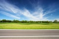 Green meadow with trees and asphalt road Royalty Free Stock Photo