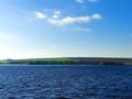 Green meadows against the blue sky and blue river Royalty Free Stock Photo