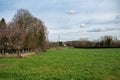 Green meadows and agriculture fields with farmhouses in the background during spring around Ternat, Belgium Royalty Free Stock Photo