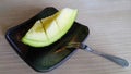 Green melon on the black plate Royalty Free Stock Photo