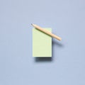 Green memo paper, sticky notes with colored pencil on blue background