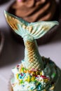 Green mermaid tail handmade on chocolate on a chocolate sugar muffin baked dessert hand pastry for a birthday party