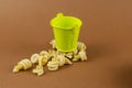 Green metal bucket and dry insalatonde pasta on a brown backgrou