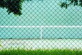 Green metal cage front the green tennis court and wall for practice. Royalty Free Stock Photo