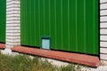 Green metal corrugated fence with brick pillars. Royalty Free Stock Photo