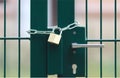 Green metal gate, locked with chain and padlock Royalty Free Stock Photo
