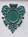 A green, metal heraldry decorated house number plaque, fixed on a wall, without number. Royalty Free Stock Photo