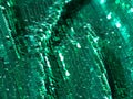 Green metalic glitter fabric folds background. Sparkling sequined textile Royalty Free Stock Photo