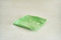 Green microfiber cleaning cloth in clear packaging on light surface Royalty Free Stock Photo
