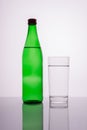 green mineral water bottle with glass on white background Royalty Free Stock Photo