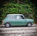 Green Mini Cooper car parked on the street in Italy.