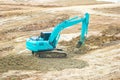 Green mini Crawler excavator hydraulics digging a hole concrete and hard rock Royalty Free Stock Photo