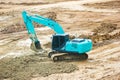 Green mini Crawler excavator hydraulics digging a hole concrete and hard rock Royalty Free Stock Photo