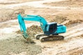 Green mini Crawler excavator hydraulics digging a hole concrete and hard rock Royalty Free Stock Photo