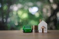 Green miniature car model, home model and coins. Finance and car loan, saving money concepts Royalty Free Stock Photo