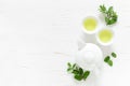 Green mint tea with fresh leaves in cups and teapot overhead on white wooden table, healthy warming drink, antioxidant beverage Royalty Free Stock Photo